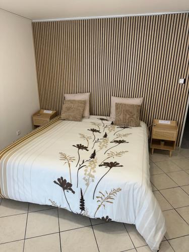 een bed met een wit dekbed met planten erop bij Là cachette in Remiremont