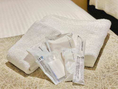 a pile of towels sitting on top of a bed at The Kanzashi Tokyo Asakusa in Tokyo