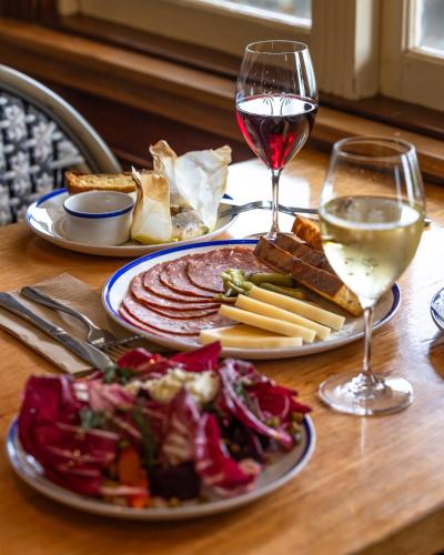 a table with a plate of food and a glass of wine at Bermagui Beach Hotel in Bermagui
