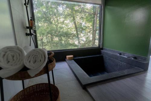 a bathroom with a tub and a large window at 方圓行止 Funyuan Village in Puli