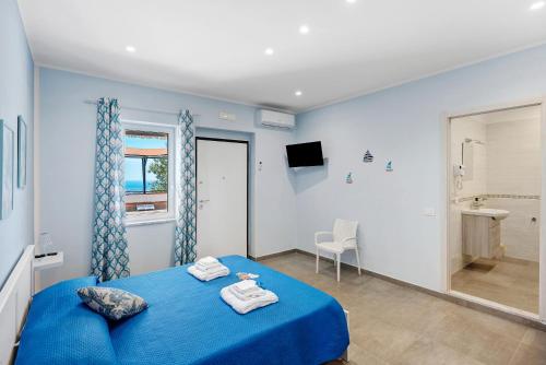 a bedroom with a blue bed with towels on it at La Fiesta House in Capaccio-Paestum