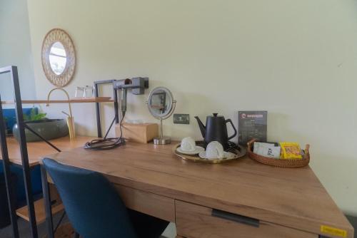 a wooden desk with a tea kettle and a basket on it at 方圓行止 Funyuan Village in Puli
