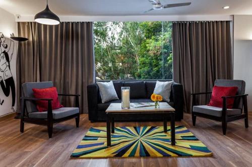 a living room with a couch and two chairs and a table at Hotel O Khammam Railway Junction Formerly Raghavendra Inn in Khammam