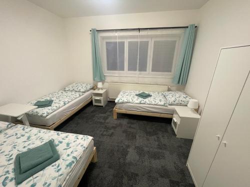 a room with two beds and a window at Apartmány Beseda in Jablonec nad Nisou
