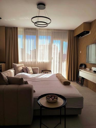 a bedroom with a large bed and a couch at Deluxe Rezidencija Bijeljina in Bijeljina