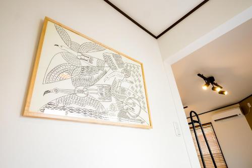 a framed drawing on a wall next to a hallway at えにしの宿 in Matsuyama