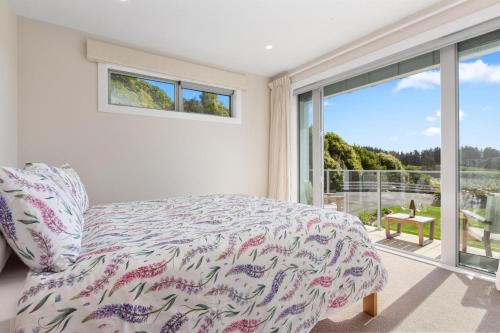 a bedroom with a bed and a large window at Aston Road Villa Bed & Breakfast in Waikanae