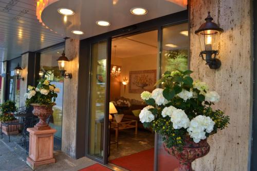 a lobby with two vases filled with white flowers at City Hotel Ost am Kö in Augsburg