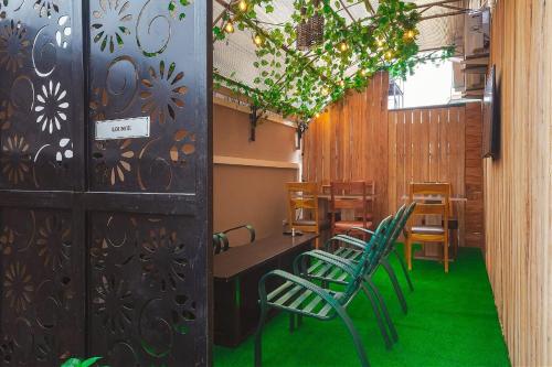 Un restaurante con sillas verdes y una mesa y una puerta. en CELJOE residents hotel and suites, en Maiyegun