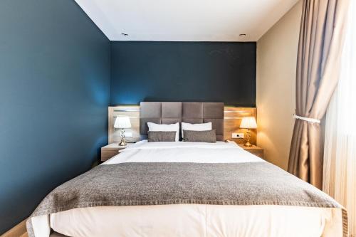 a bedroom with a large bed with a blue wall at The Sign Degirmen Hotel&Spa Wellness in Istanbul
