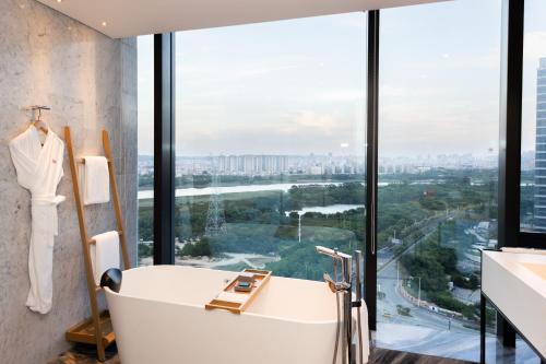 a bath tub in a bathroom with a large window at Crowne Plaza Quanzhou Riverview by IHG in Quanzhou