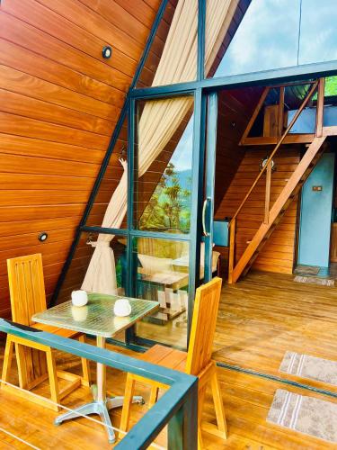 a room with a table and chairs on a wooden floor at Eco Cabana Bellwood in Nikawatawana