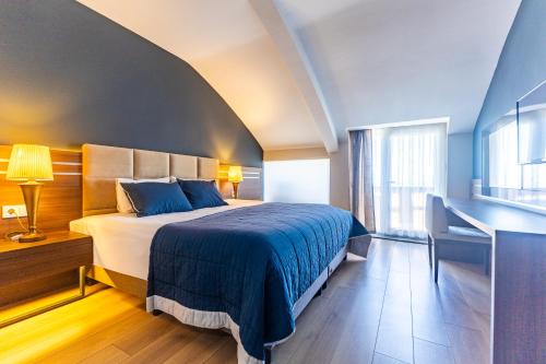 a bedroom with a large bed with a blue blanket at The Sign Degirmen Hotel&Spa Wellness in Istanbul