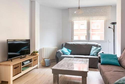 a living room with a couch and a tv at Santander Centro in Santander