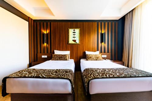 two beds in a hotel room with wood paneling at The Sign Degirmen Hotel&Spa Wellness in Istanbul