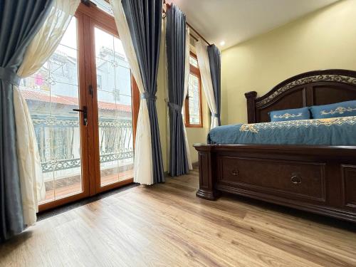 a bedroom with a bed and a large window at Phuong Villa in Da Lat