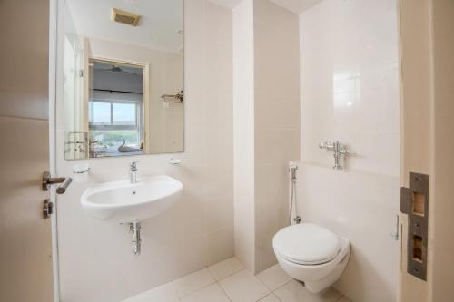a white bathroom with a toilet and a sink at Ten4teen Luxury Apartment in Galle