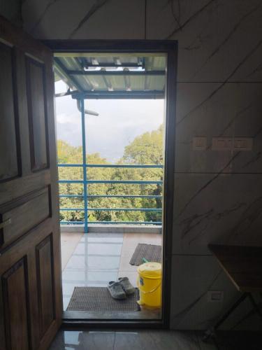 a door leading into a room with a bucket at Nachiyar Hotel in Kanthalloor