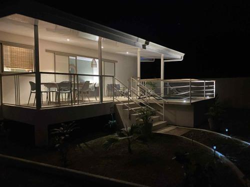 a house at night with a balcony with tables and chairs at Moorea Villa Tea in Afareaitu