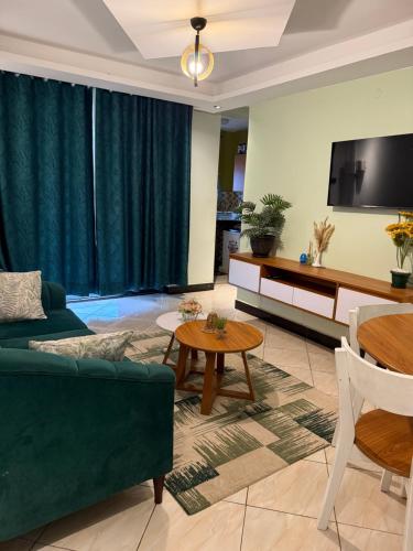 a living room with a green couch and a table at Fivas Residences in Arua