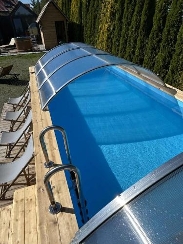 a blue swimming pool with a chair next to it at Happy Jura in Biskupice