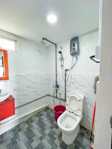 a bathroom with a toilet and a sink at Kundasang Farmhouse in Kampong Kundassan