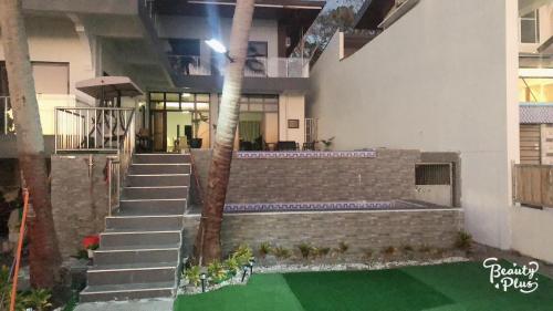 a building with a staircase and a palm tree at Clarin's Beach in Sampong