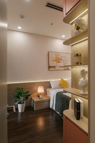 a bedroom with a bed and a desk with a lamp at Vinhomes Smart City Tây Mỗ Dani Apartment in Hanoi