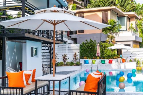 an umbrella and chairs next to a swimming pool at 哦先生的海景别墅 Aoyon Beach in Phuket Town
