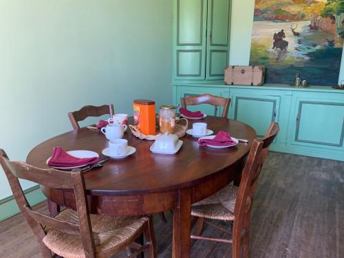 einen Holztisch mit Teezubehör darüber in der Unterkunft Les Buis, Chambre des Poétesses in Chasseneuil-du-Poitou