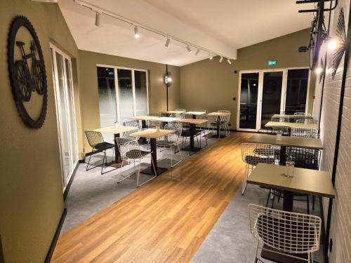 ein Esszimmer mit Tischen, Stühlen und Fenstern in der Unterkunft Hôtel Morphée Lille Villeneuve d'Ascq in Villeneuve d'Ascq