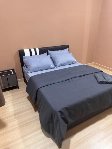 a bedroom with a large bed with blue sheets and pillows at MU Homestay in Simpang Ampat