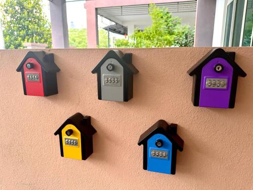 a wall with different colored bird houses on it at MU Homestay in Simpang Ampat