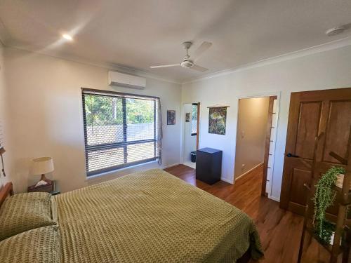 a bedroom with a bed and a window at Garden Street Haven in Cooktown