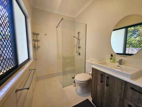 a bathroom with a shower and a toilet and a sink at Garden Street Haven in Cooktown