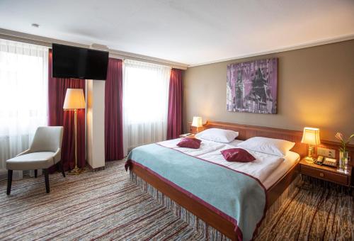 a hotel room with a bed and a flat screen tv at Hotel Pelikan in Schwäbisch Gmünd
