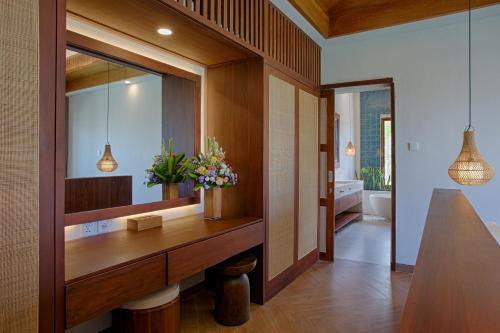 y baño con tocador de madera y espejo. en My Villa and Resort Canggu, en Canggu