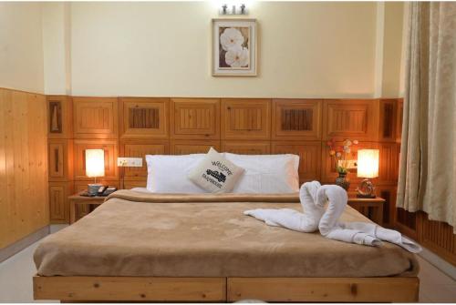 a bedroom with a bed with a towel on it at Hotel Sanjeevny in Bajaura