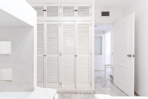 ein weißer Schrank in einem Schlafzimmer mit weißen Wänden in der Unterkunft Expoholidays - Puerto Aguadulce (Av Carlos III 432 3ºI) in Aguadulce