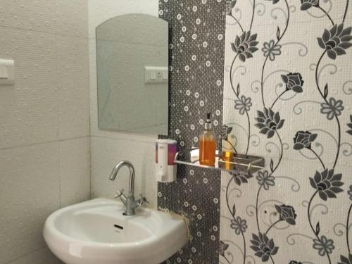 a bathroom with a sink and a mirror at Sona Hotel and Restaurant By StayApart in Kanatal