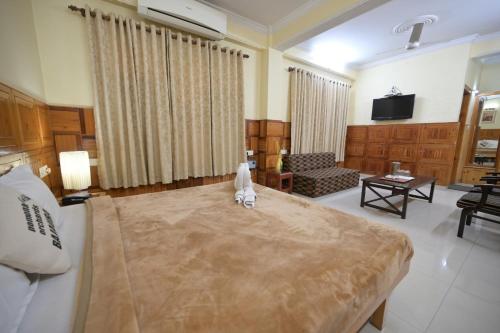 a large living room with a bed and a couch at Hotel Sanjeevny in Bajaura