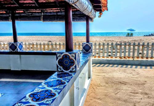 a bench with a view of the beach at ETHER Marari Beachfront in Mararikulam