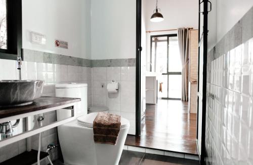 a white bathroom with a sink and a toilet at Kunna House in Ko Yao Noi