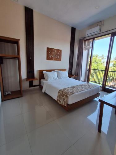 a bedroom with a bed and a large window at L'JAVAS VILLAS in Kalibendo