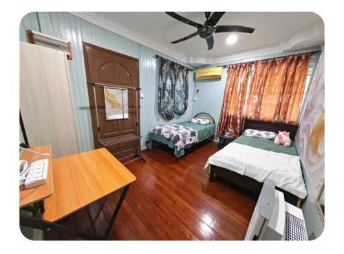 a room with two beds and a desk and a desk at Forest Way Home Sepilok Sandakan in Sandakan