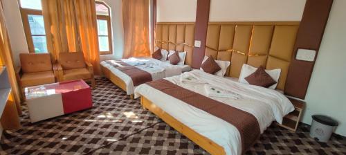 a hotel room with two beds and a chair at Gulsitara Resorts-Gulmarg in Gulmarg