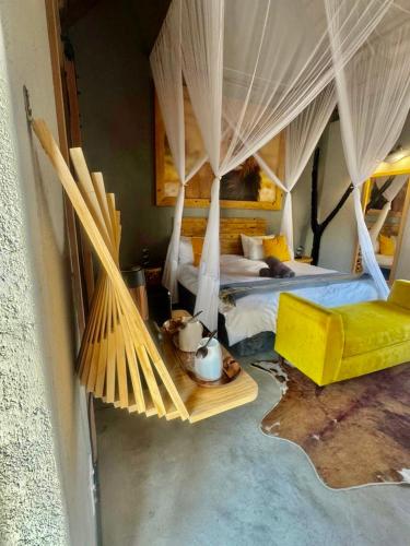 a bedroom with two beds and a hammock in it at Lindiwe Safari Lodge in Hoedspruit