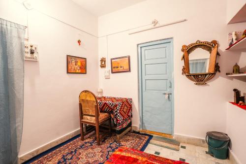 a room with a table and a chair and a mirror at Marigold Home Stay in Jaisalmer