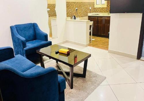 a living room with two blue chairs and a coffee table at المهاجر للشقق المخدومة فرع قريش in Jeddah