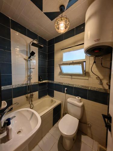 a bathroom with a toilet and a sink and a tub at Lamour GEM Pyramids View Hotel & Jacuzzi in Cairo